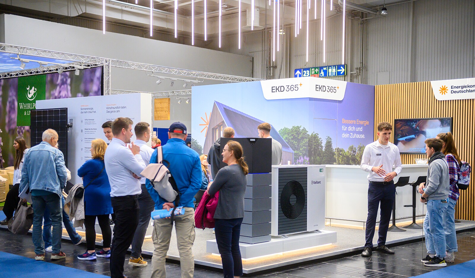 Visitors stand and chat in front of a stand at the Building and Living theme world