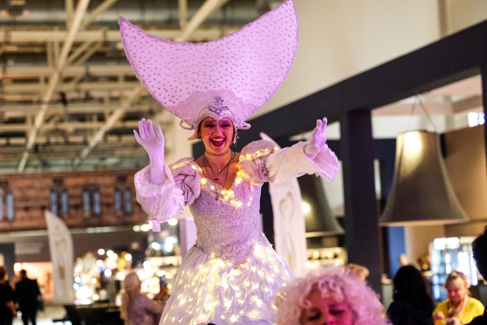 A stilt walker in the LIFESTYLE theme world smiles at the camera.