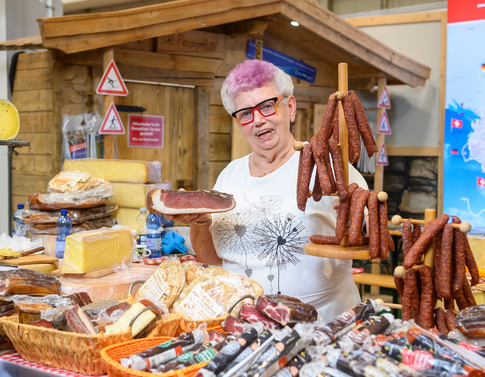 A woman with pink dyed hair shows off sausage specialties