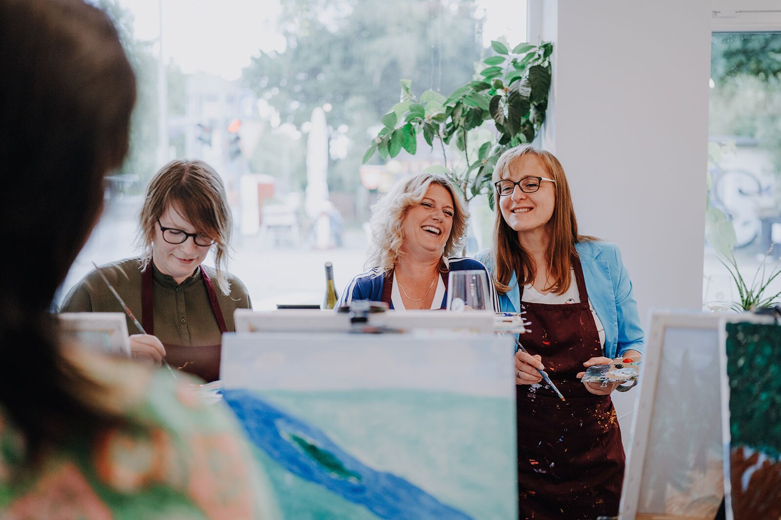 Im Rahmen des Events Entkorkte Kunst halten zwei Teilnehmerinnen Weingläser in den Händen unterhalten sich.